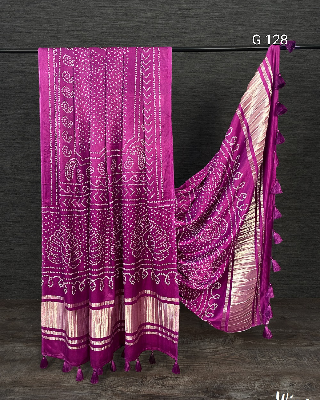 Purple and white patterned fabric with tassels on a dark background
