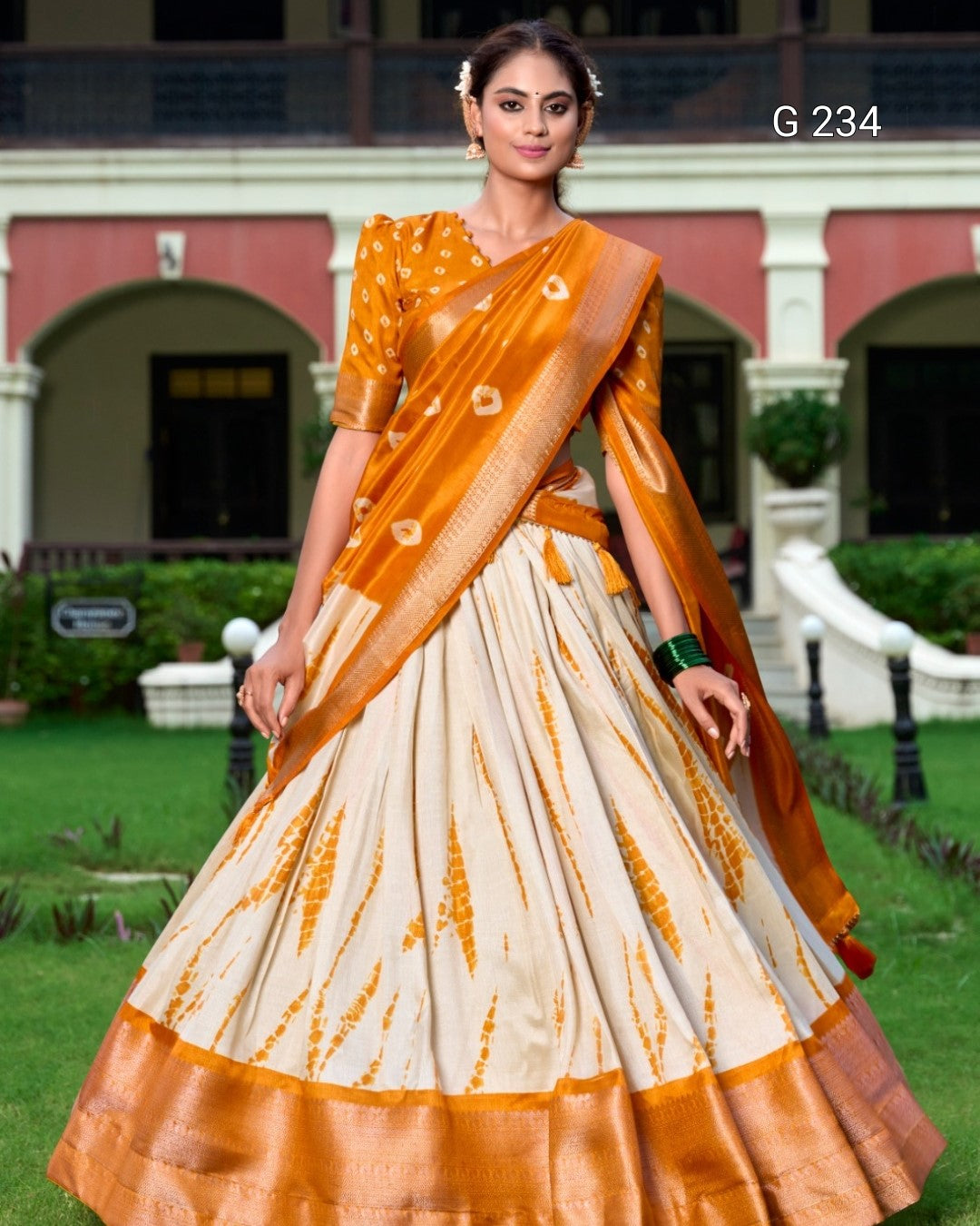 Woman wearing a traditional saree with a patterned design in an outdoor setting.