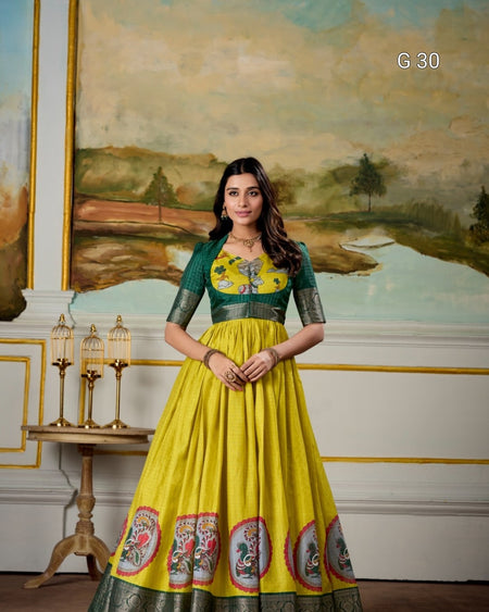 Woman in a yellow and green dress with floral design standing in front of a painting.