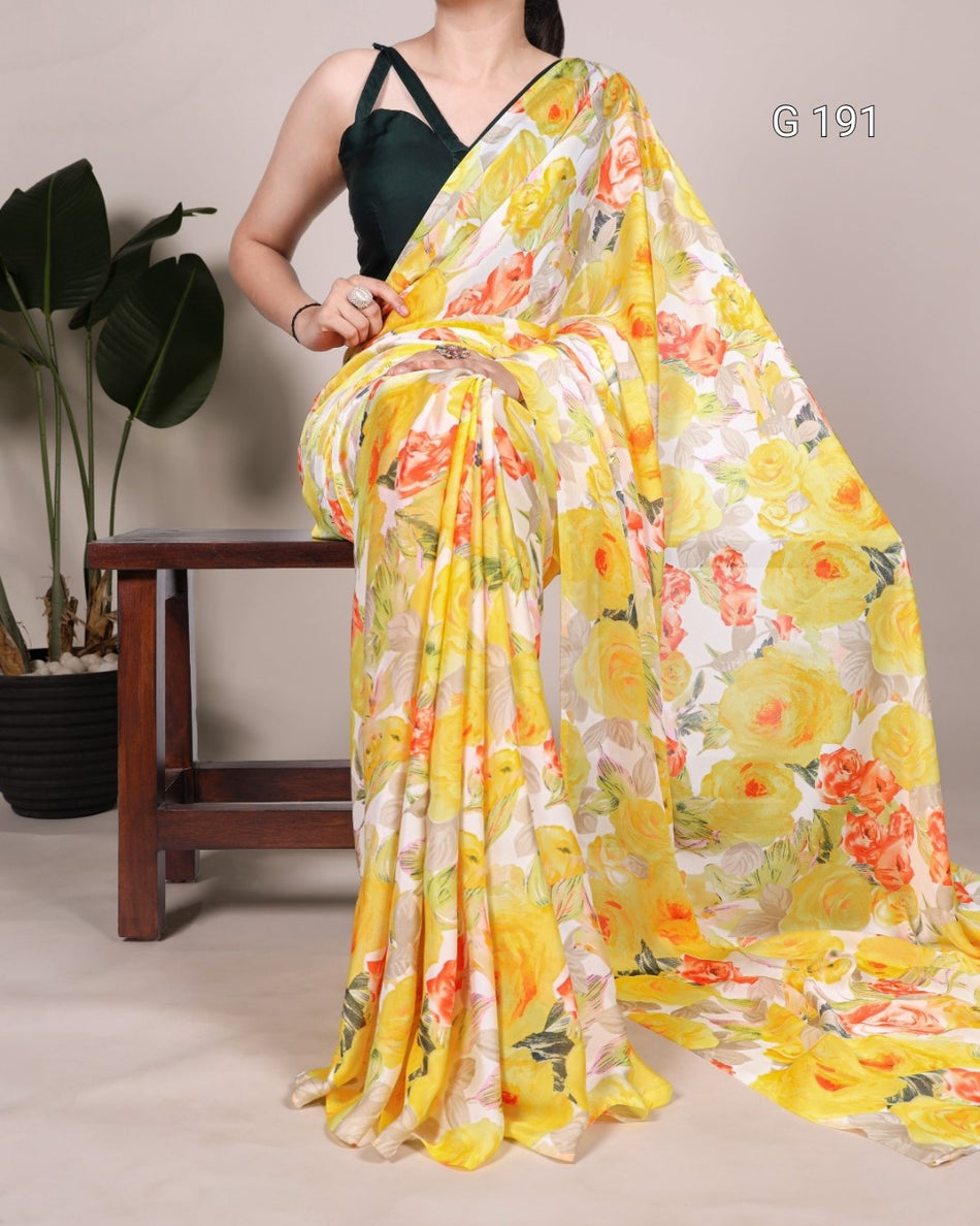 Woman holding a yellow floral saree with a plant and wooden stool in the background