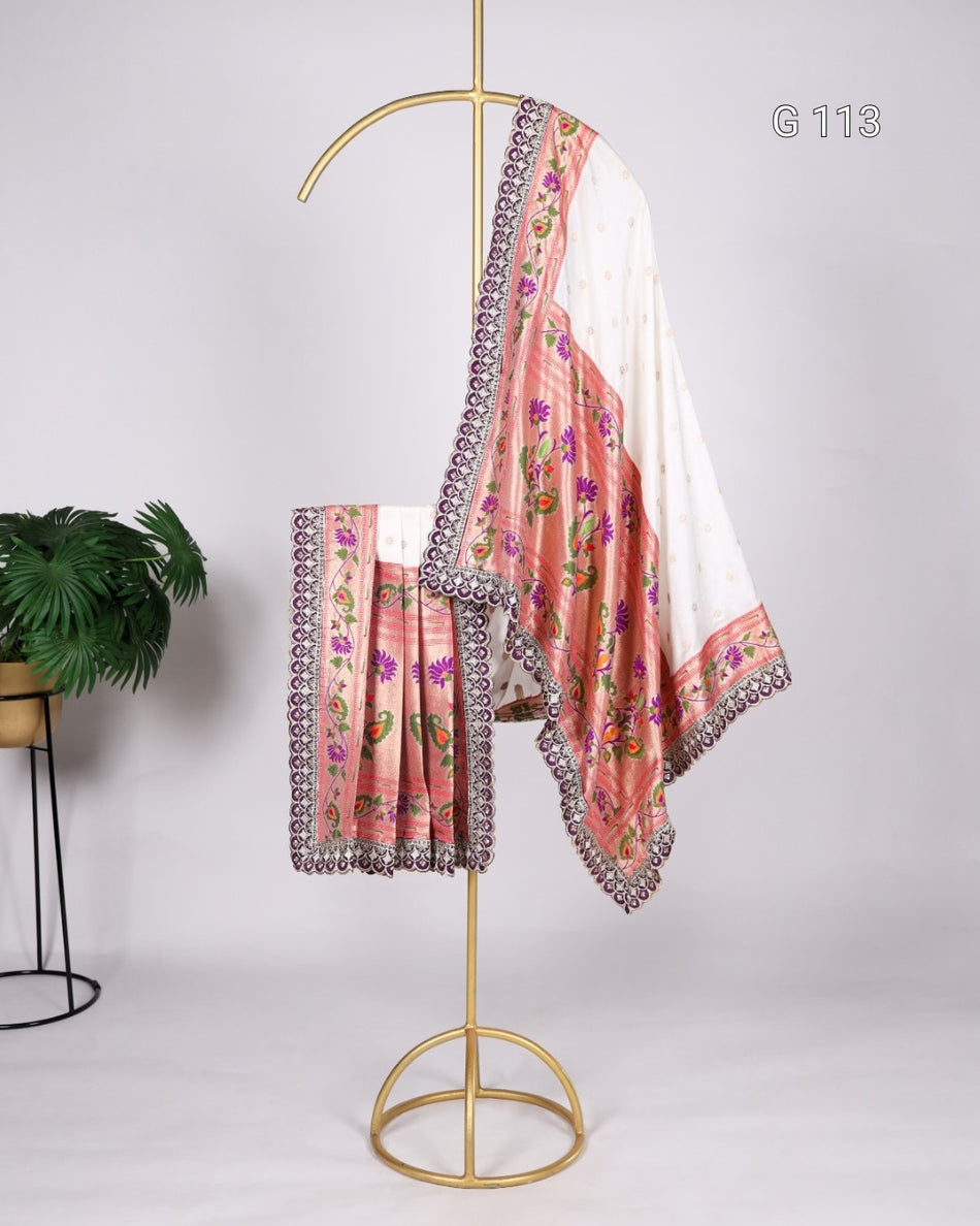 Saree with floral patterns and decorative border on a gold stand against a white background