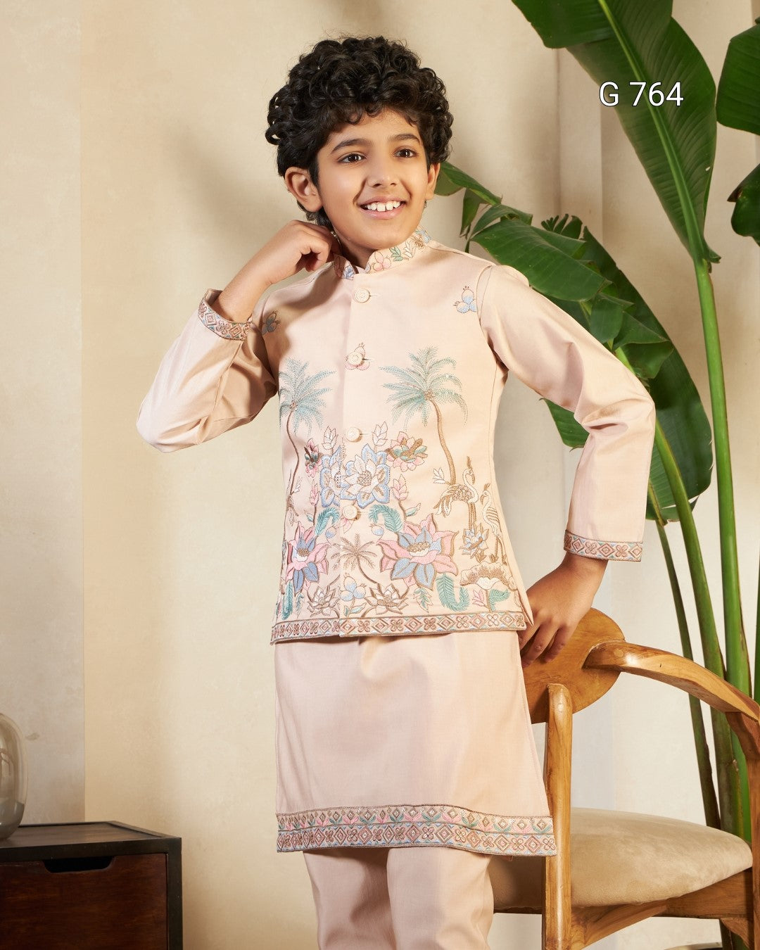 Child wearing a traditional outfit with floral patterns in a room with a plant and chair.