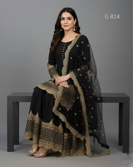 Woman wearing a black and gold traditional outfit sitting on a bench against a gray background.