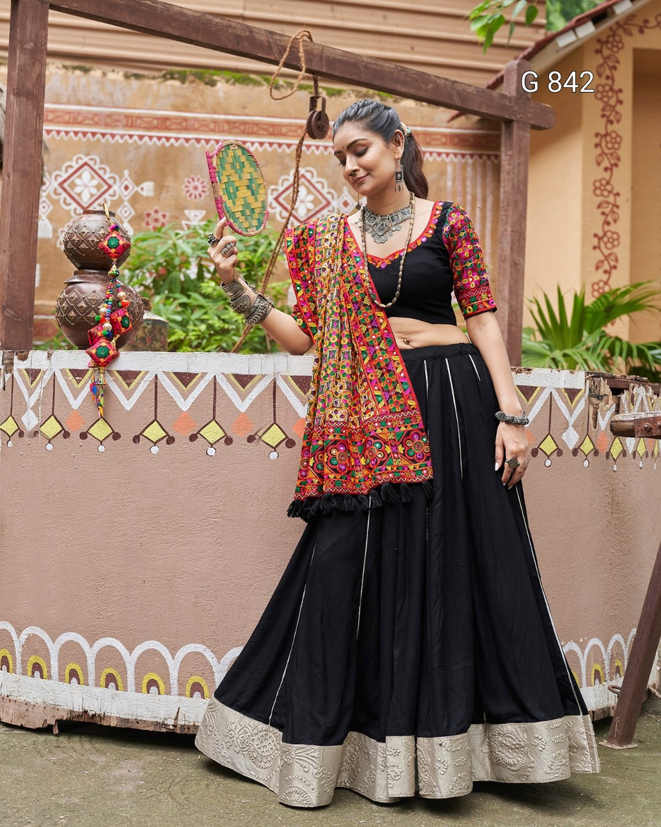 Woman in traditional black and red outfit with decorative elements in a festive setting