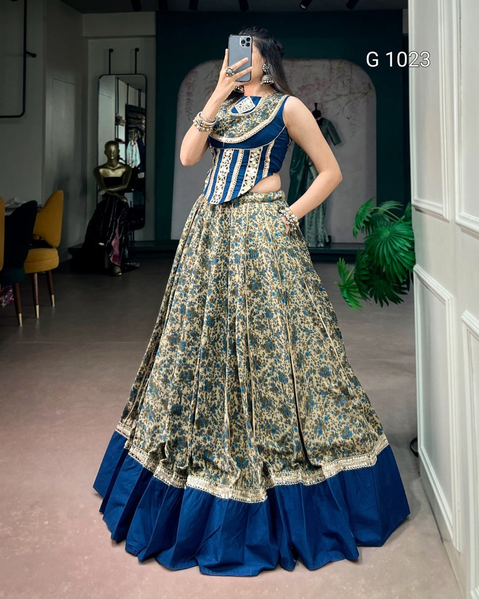 A woman takes a mirror selfie in a boutique wearing a traditional Indian outfit consisting of a navy blue sleeveless top with gold embroidery and a matching flared skirt with a gold floral pattern and a solid navy blue hem.