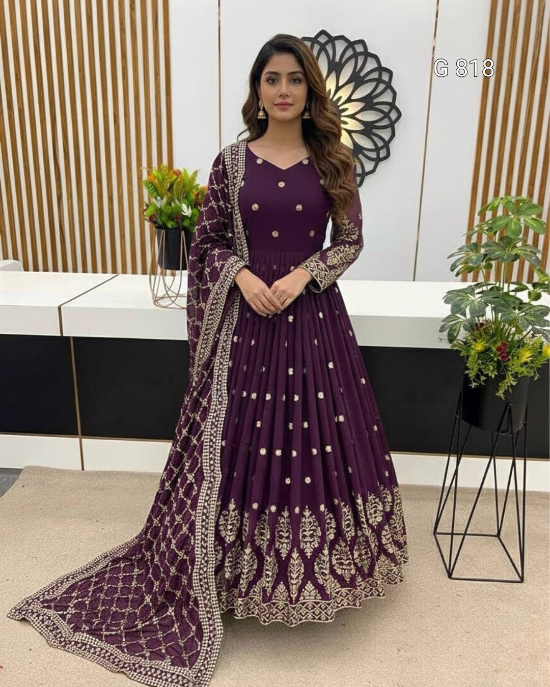 Woman in a purple traditional outfit with gold embroidery in an indoor setting.