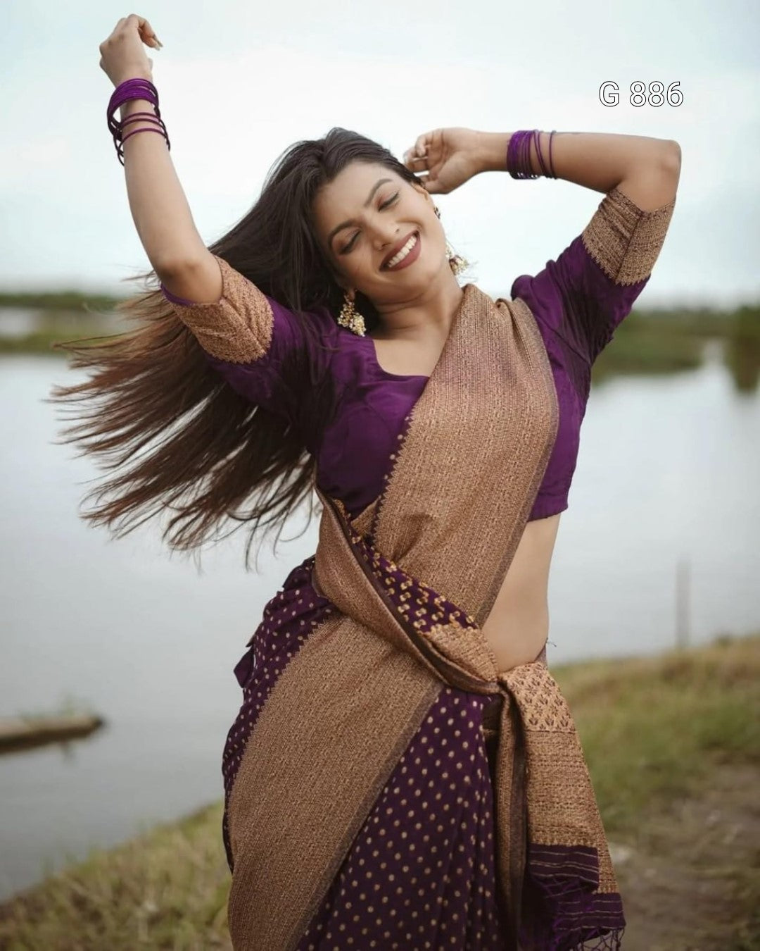 Woman in a purple and brown traditional outfit by a body of water