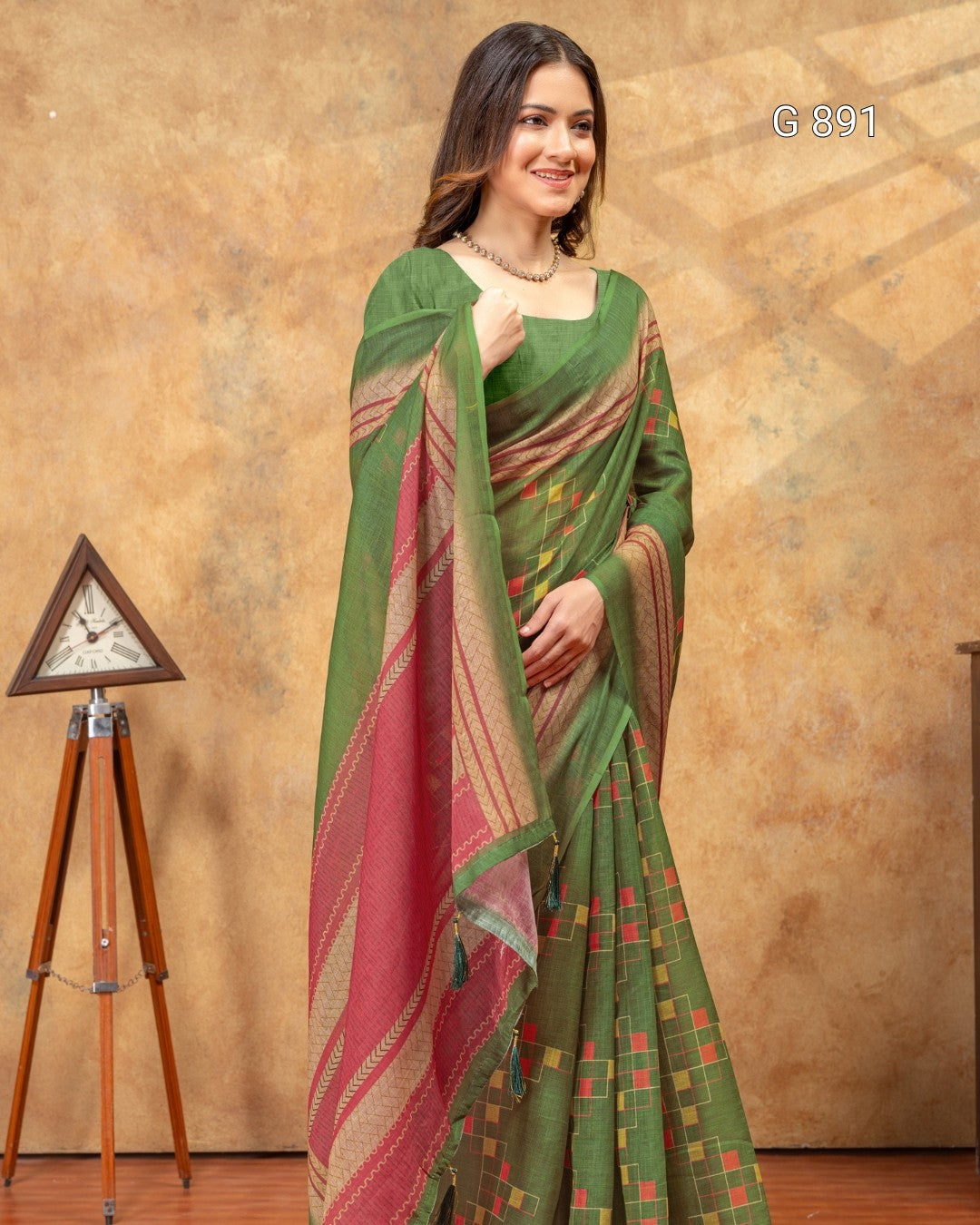 Woman wearing a green and red saree with a decorative background