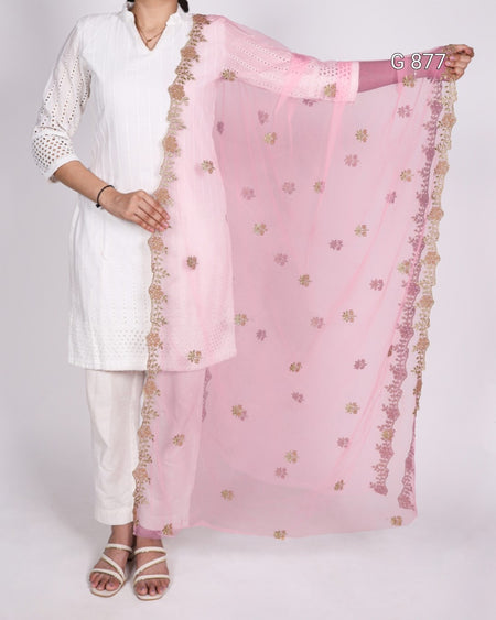 Person wearing a white outfit with a pink dupatta featuring gold patterns on a plain background