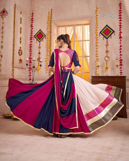 Woman in a colorful saree with a decorated room in the background