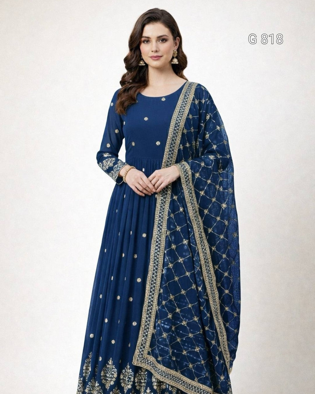 Woman wearing a blue anarkali suit with intricate patterns on a white background