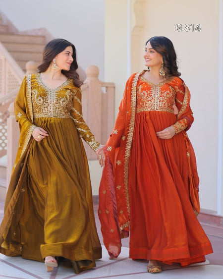 Two women in traditional embroidered dresses standing indoors.