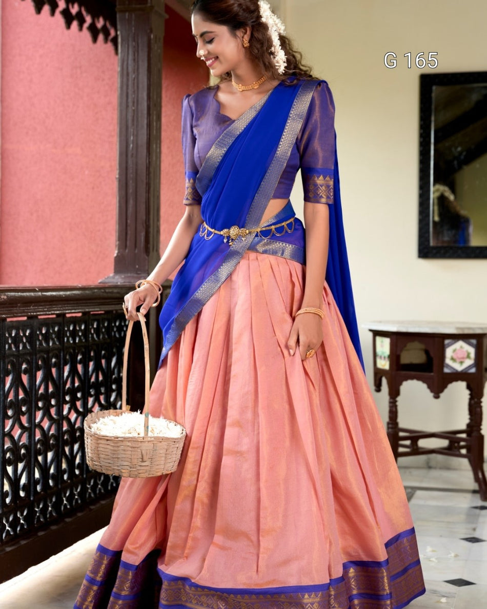 Woman wearing a traditional saree with a blue blouse and peach skirt, holding a basket.