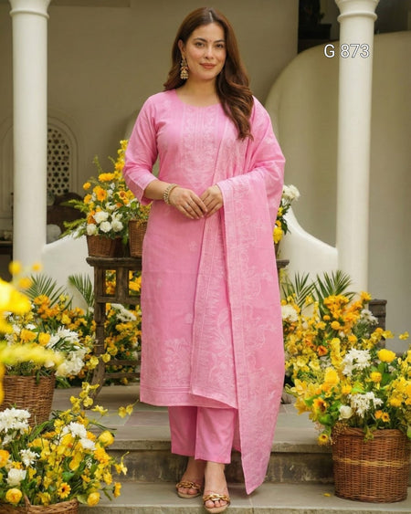 Woman in a pink traditional outfit standing in front of floral decorations