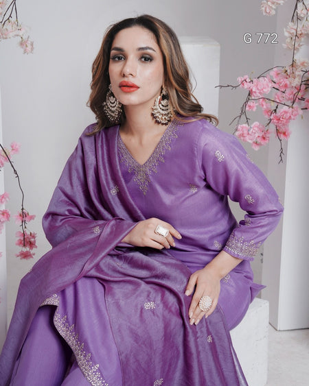 Woman wearing a purple traditional outfit with floral decorations in the background