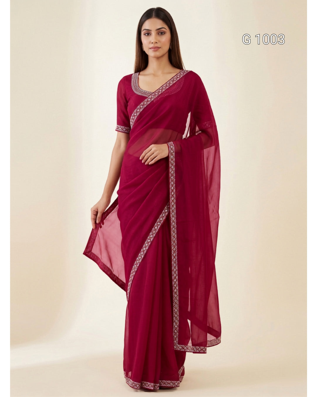 A woman modeling a deep magenta saree with silver patterned borders, standing against a plain beige studio background. The text 'G 1003' is visible in the top right corner.