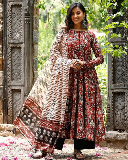 Woman wearing a patterned dress standing outdoors with decorative elements.