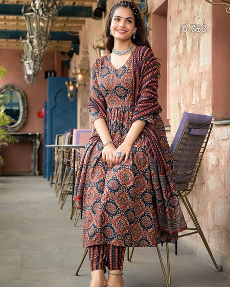 Woman wearing a patterned dress in an indoor setting with decor elements.