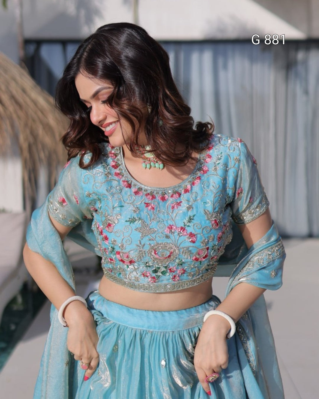 Woman wearing a light blue embroidered traditional outfit with a blurred background