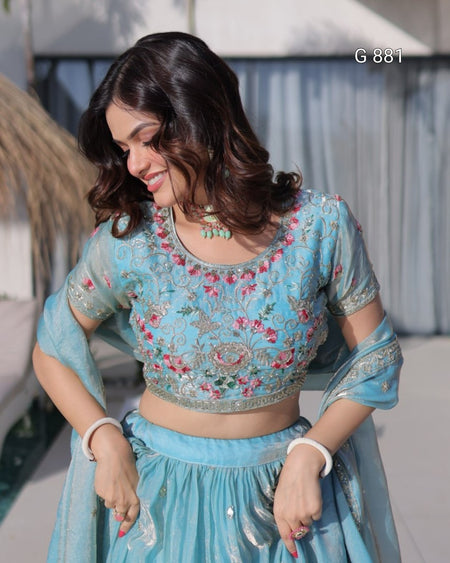 Woman wearing a light blue embroidered traditional outfit with a blurred background