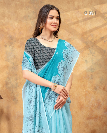 Woman wearing a light blue saree with floral patterns on a brown background