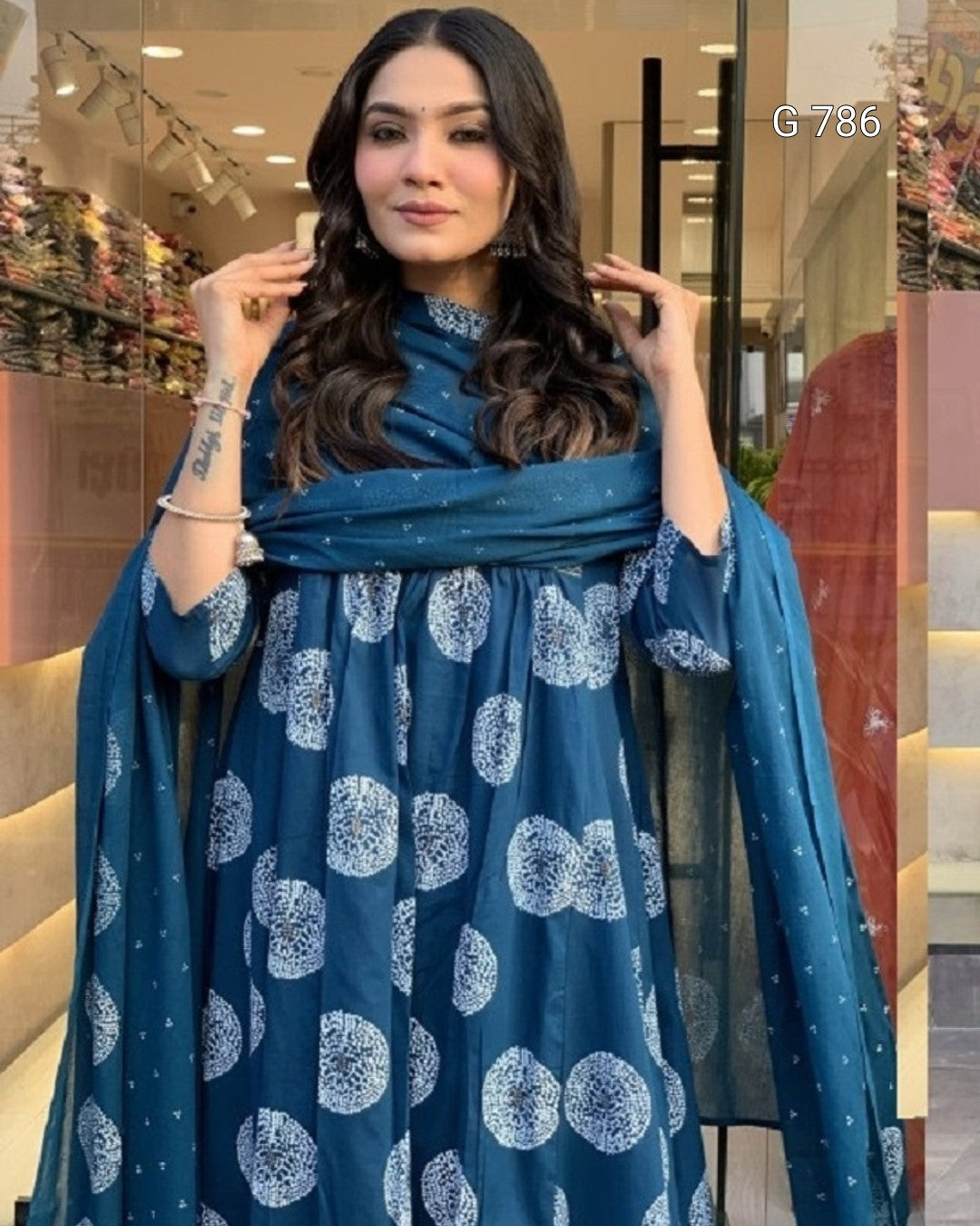 Woman wearing a blue dress with white patterns indoors