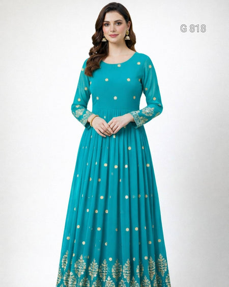 Woman wearing a teal dress with gold patterns on a white background