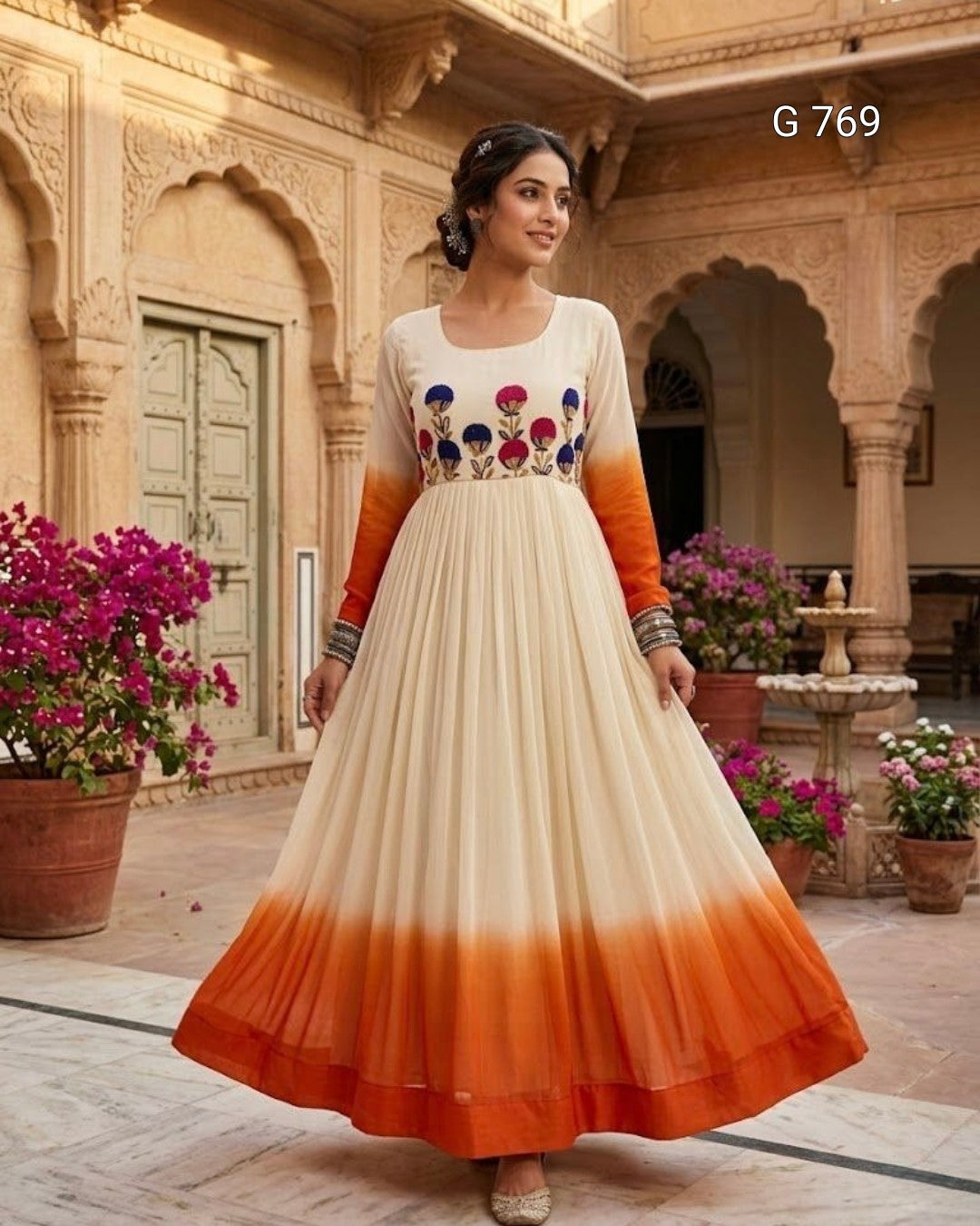 Woman wearing an orange and white dress with floral patterns in a decorative setting.