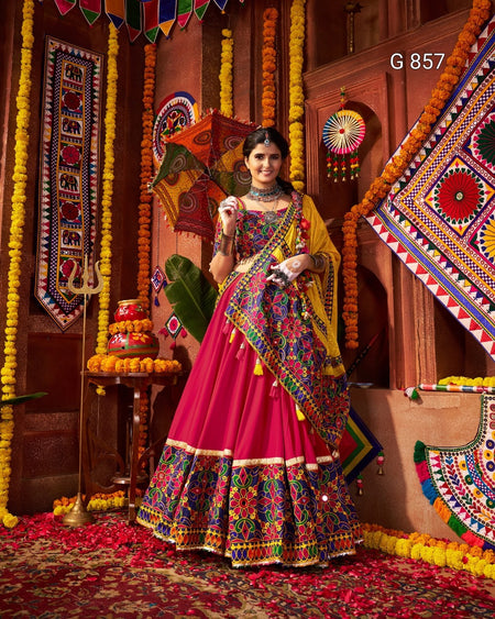 Woman in a colorful traditional outfit standing in a decorated room with vibrant patterns and decorations.