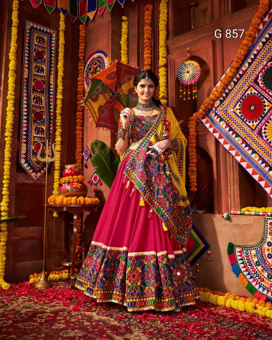 Woman in a colorful traditional outfit standing in a decorated room with vibrant patterns and decorations.
