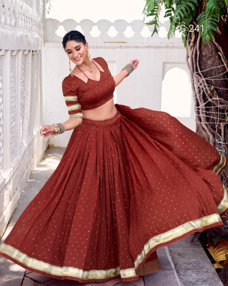 Woman in a traditional maroon outfit with gold details dancing outdoors.