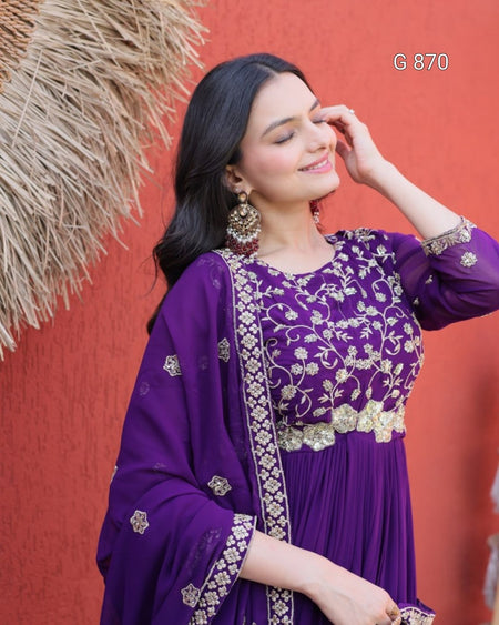 Woman in a purple traditional outfit with gold embroidery against a red background