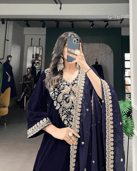 Person wearing a dark blue embroidered outfit in a store setting.