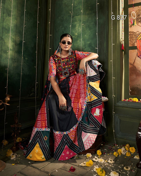 Woman in a colorful traditional outfit standing against a dark green wall with decorative elements.