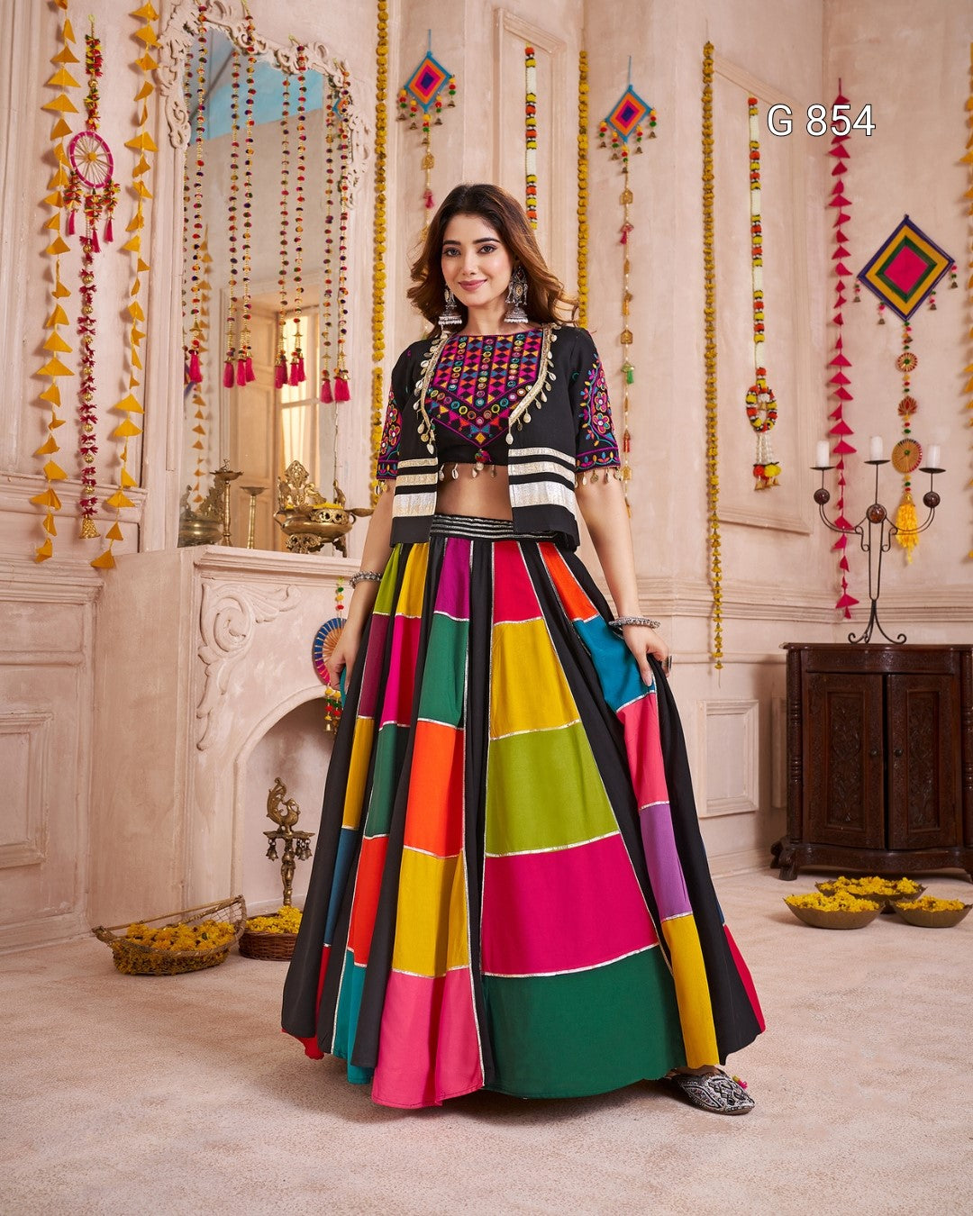 Woman in a colorful traditional outfit standing in a decorated room.