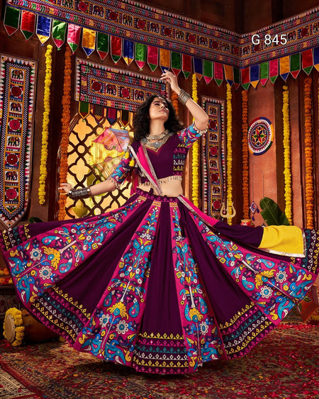 Woman in a traditional purple and colorful outfit with a decorated background