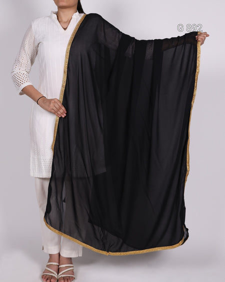 Person wearing a black dupatta with gold border draped over one shoulder on a white background