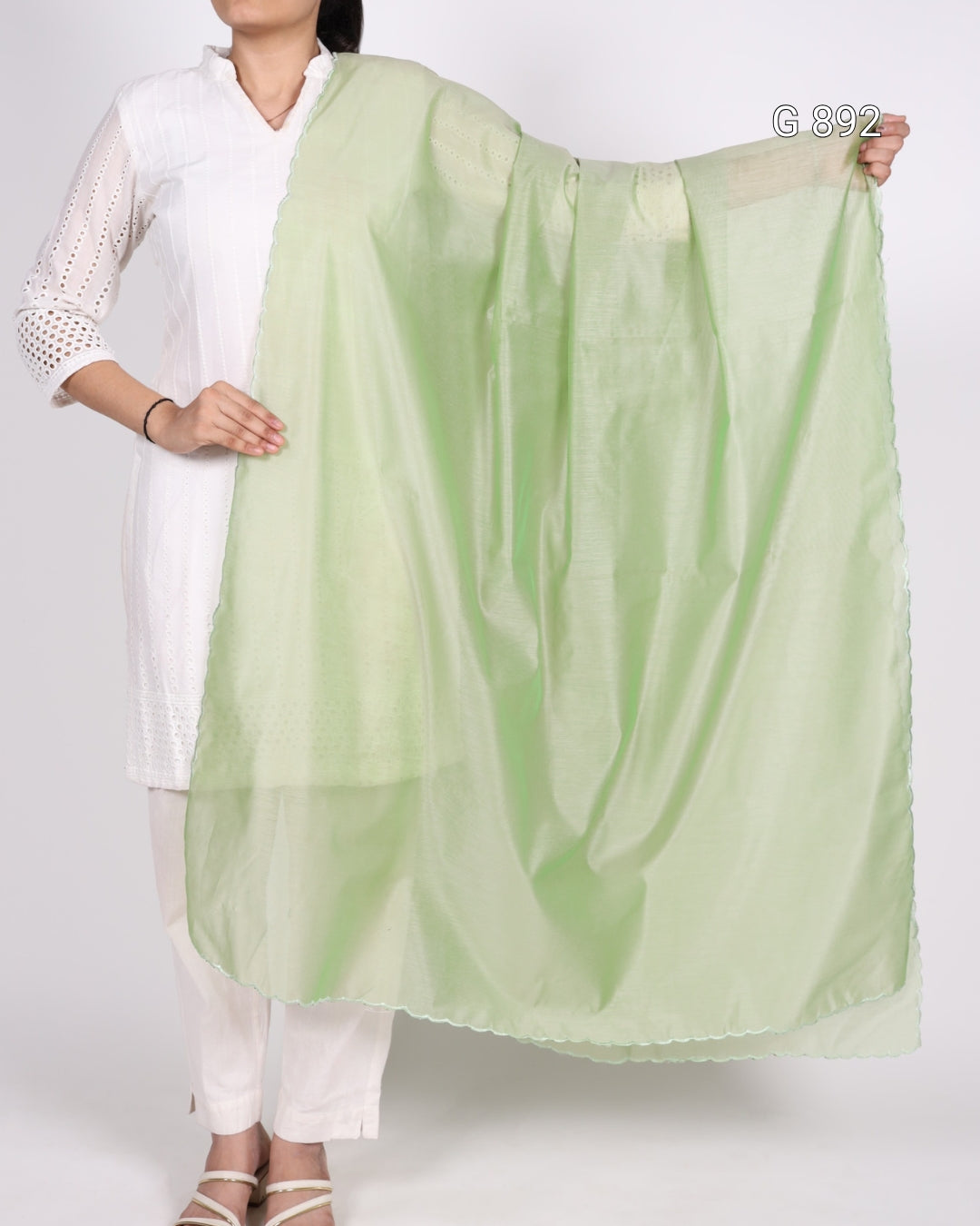 Person holding a light green scarf against a white background