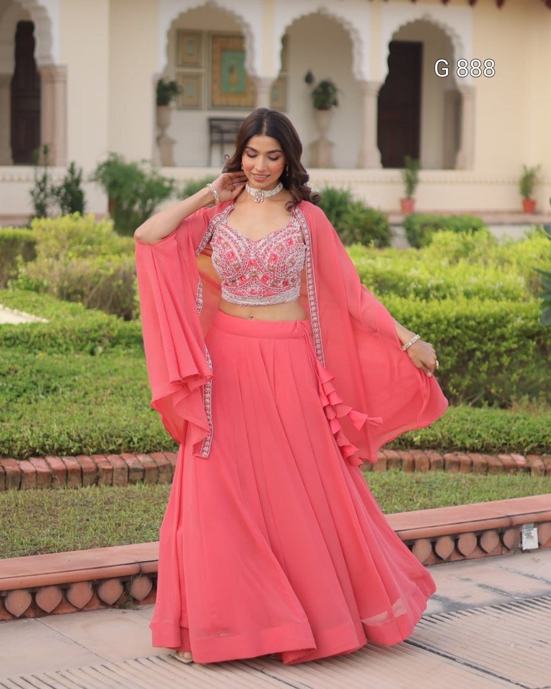 Woman in a pink traditional outfit standing in a garden setting