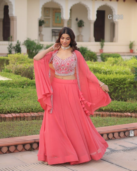 Woman in a pink traditional outfit standing in a garden setting