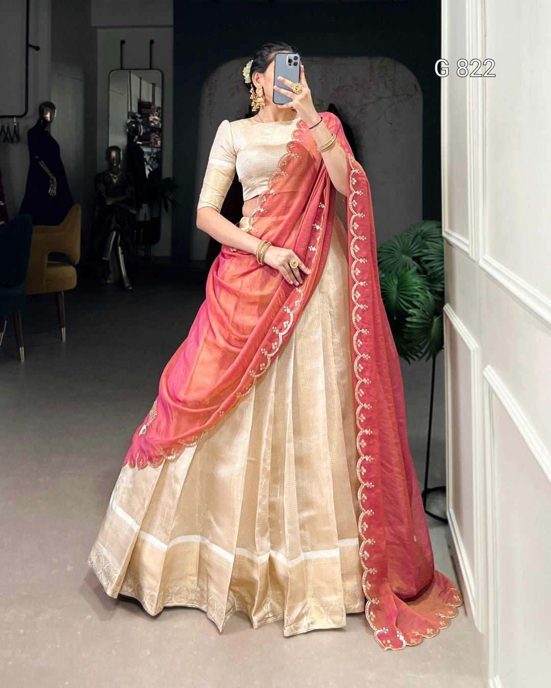 Woman wearing a traditional outfit with a pink saree in an indoor setting
