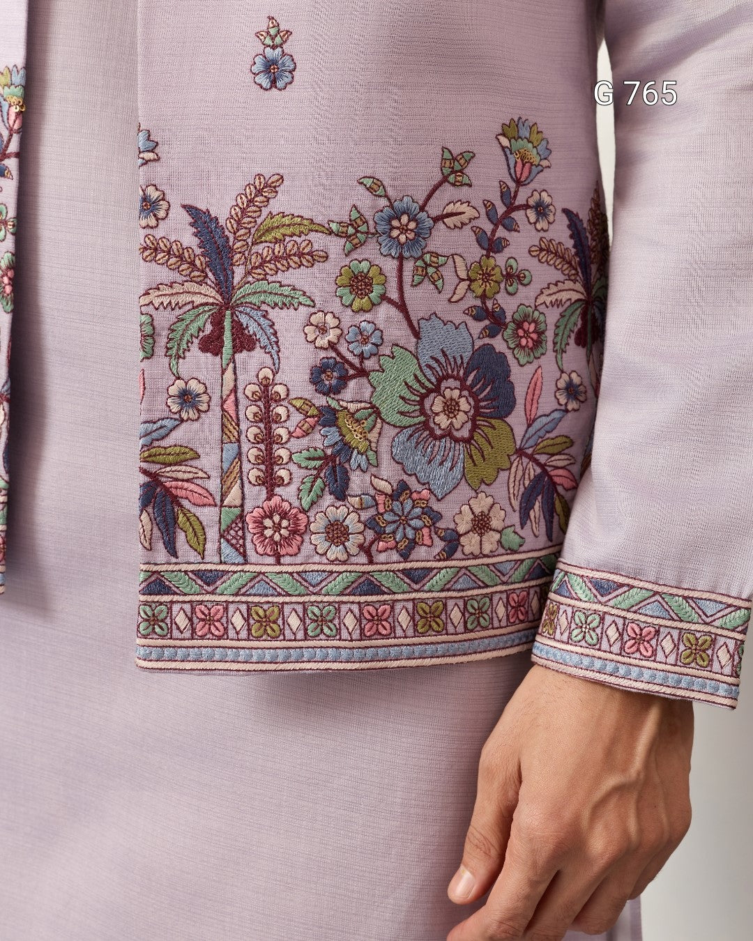 Close-up of a garment with intricate floral embroidery on a plain background
