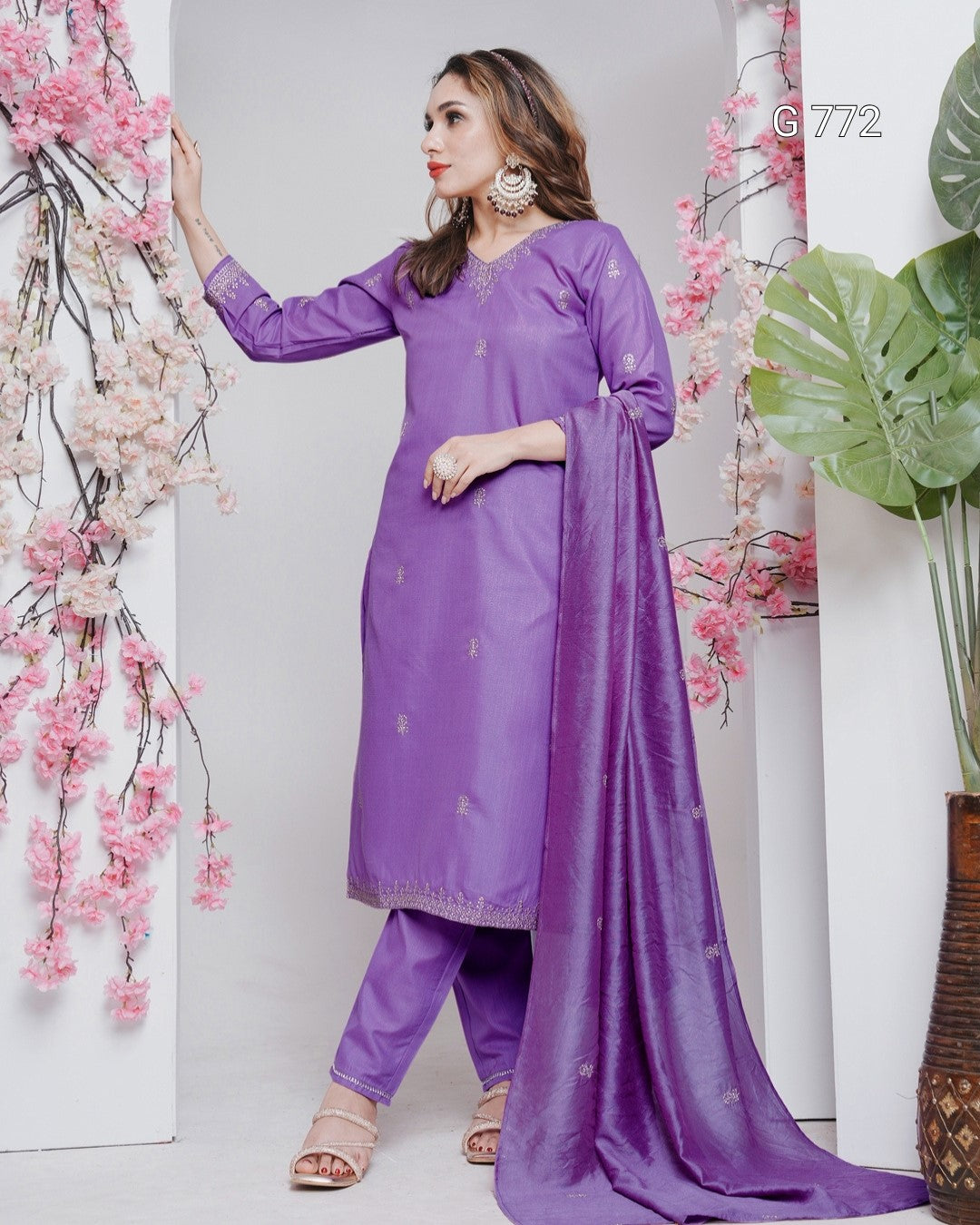 Woman in a purple traditional outfit with a floral background