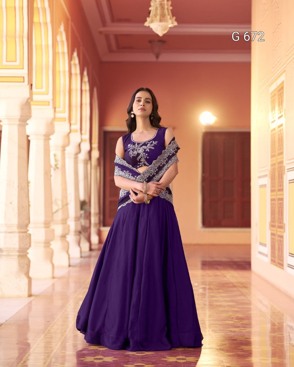 Woman in a purple evening gown with silver embellishments standing in an ornate hallway.