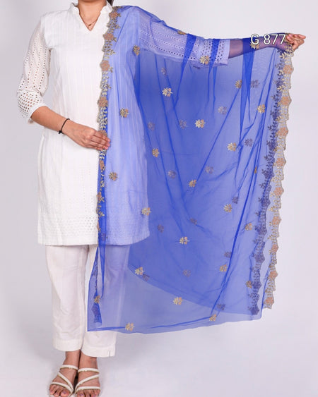 Person holding a blue embroidered scarf against a white background