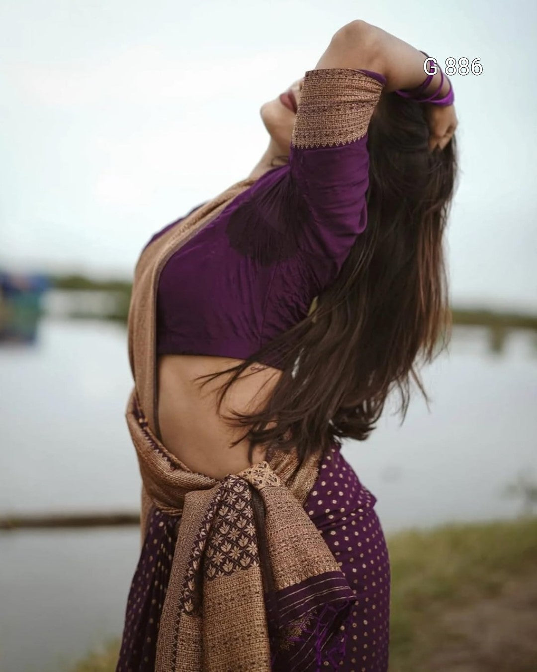 Woman in a purple outfit with a brown scarf standing outdoors