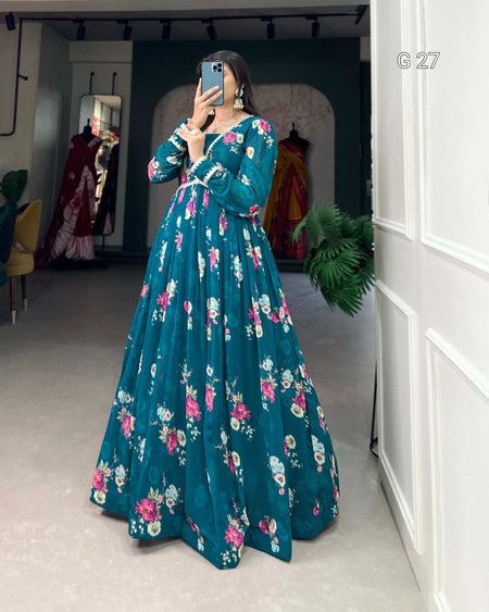Person wearing a teal floral dress in a room with mirrors and plants.