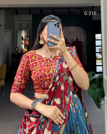 Person wearing a colorful saree with a patterned blouse, standing indoors.