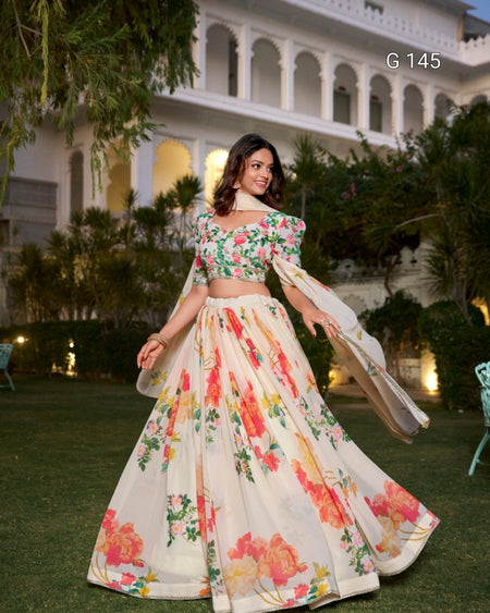 Woman in a floral off-shoulder top and skirt standing outdoors with a building in the background