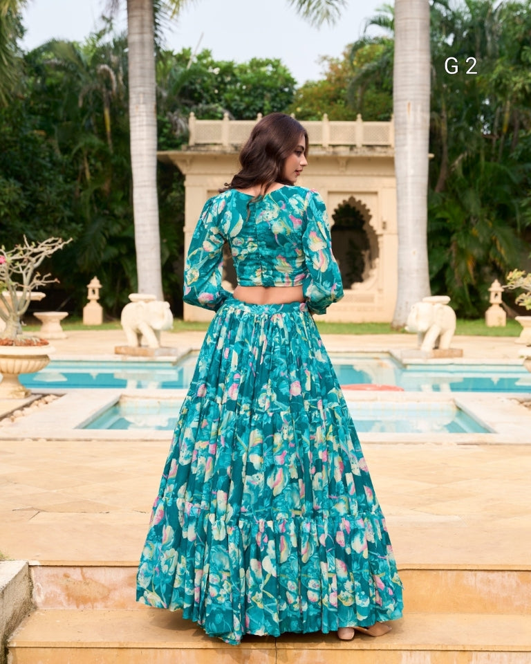Woman in a teal floral dress standing in a garden with a pool and statues.